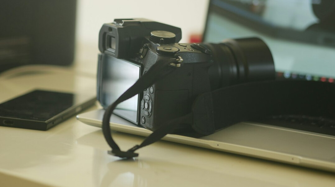 Equipamento de filmagem organizado sobre uma mesa, câmara e lentes